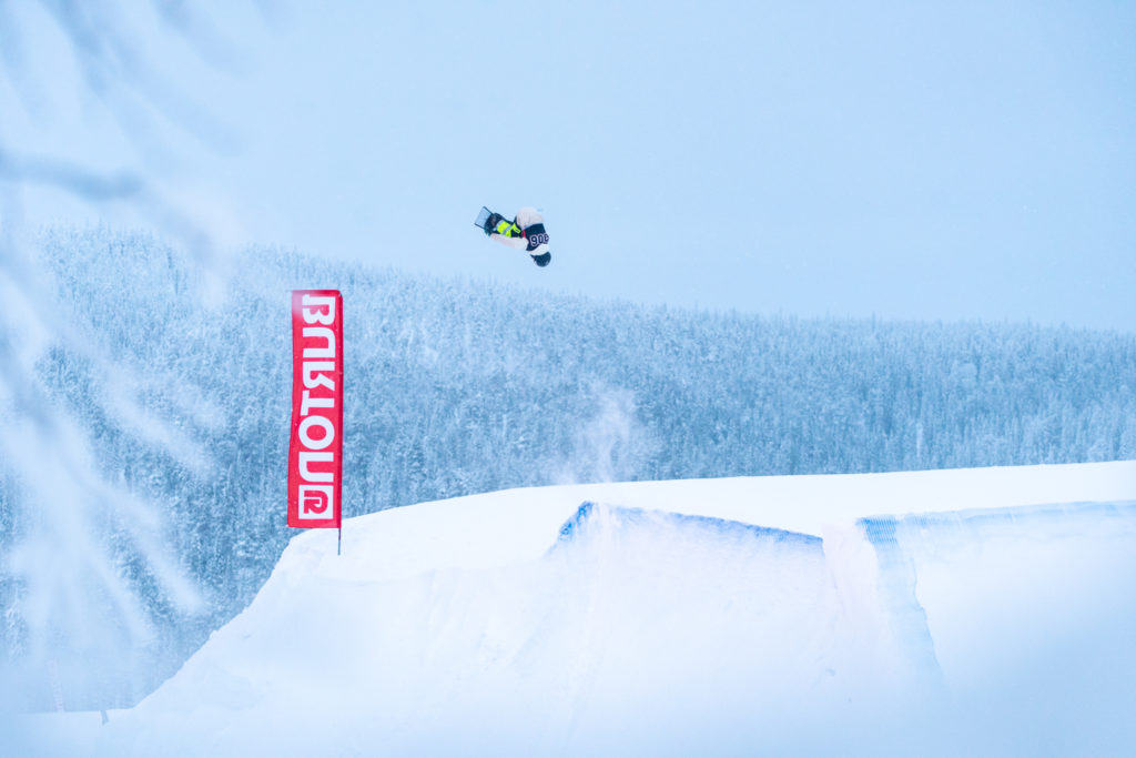 A snowboarder flying over a slope