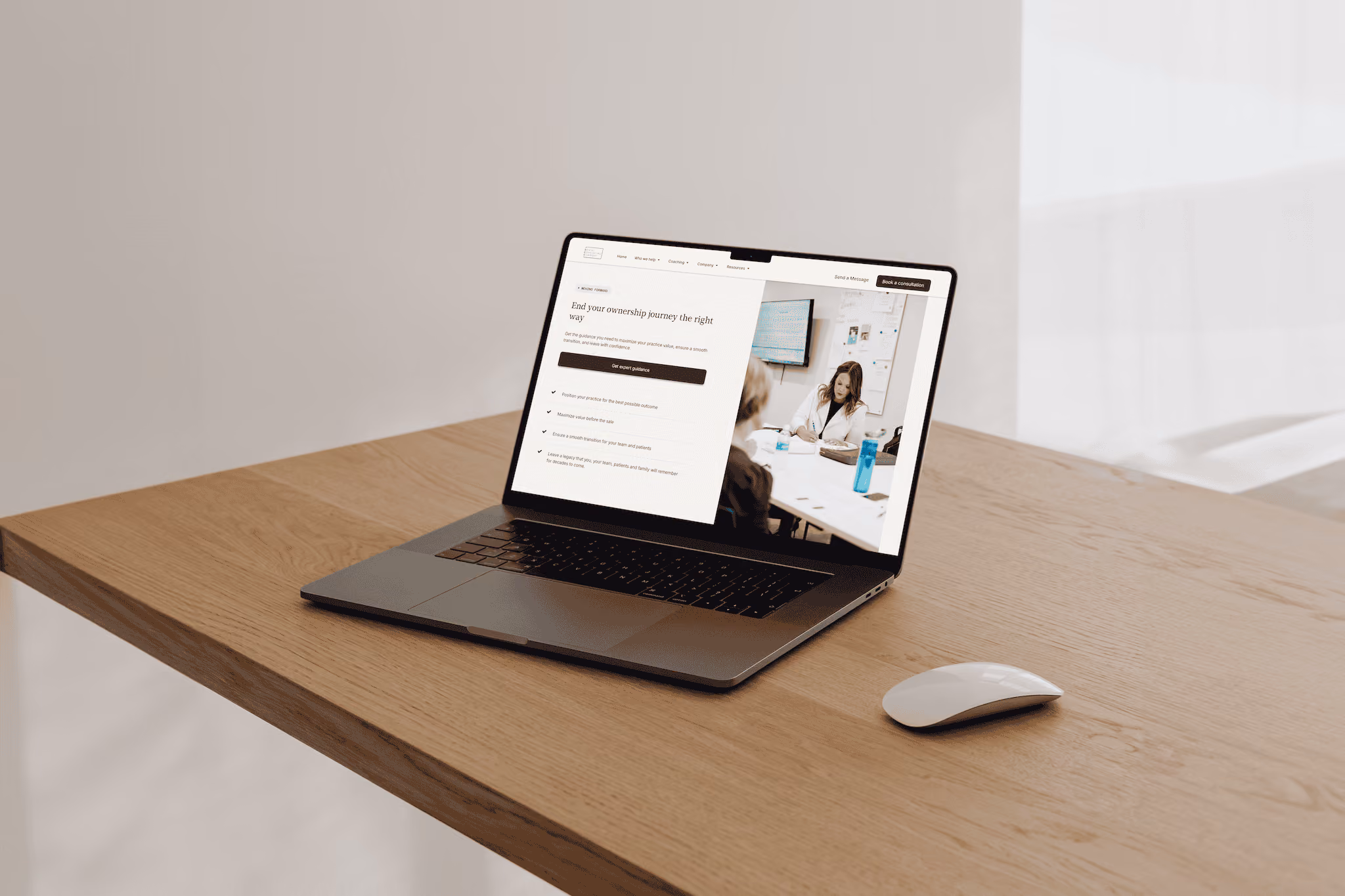 Open laptop on wooden desk showing a webpage with a woman writing in a meeting room photo.