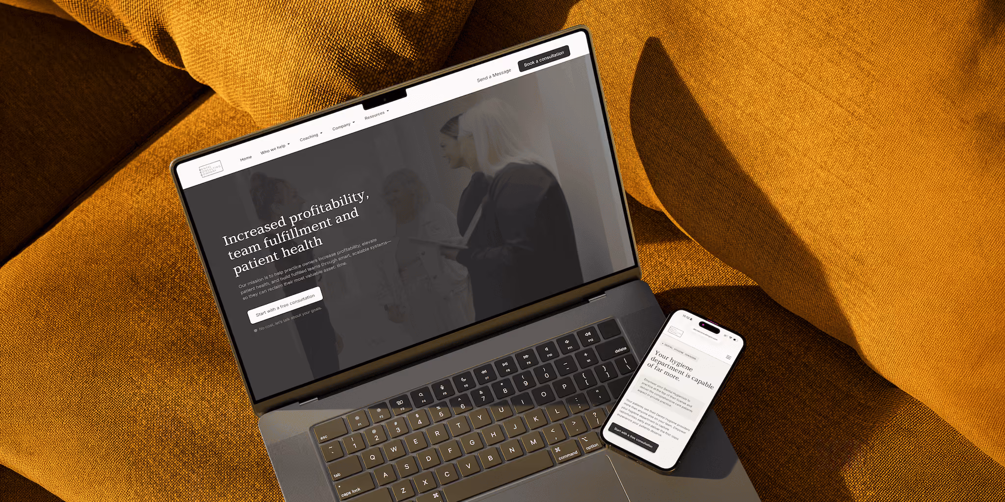 Laptop and smartphone on mustard yellow fabric showing a website about dental practice growth.