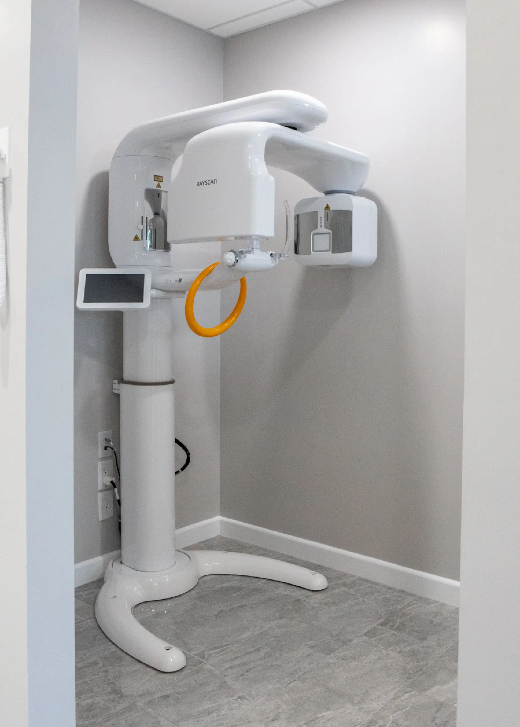 Dental cone beam CT scanner in a room, used for detailed 3D imaging of teeth and jaws.