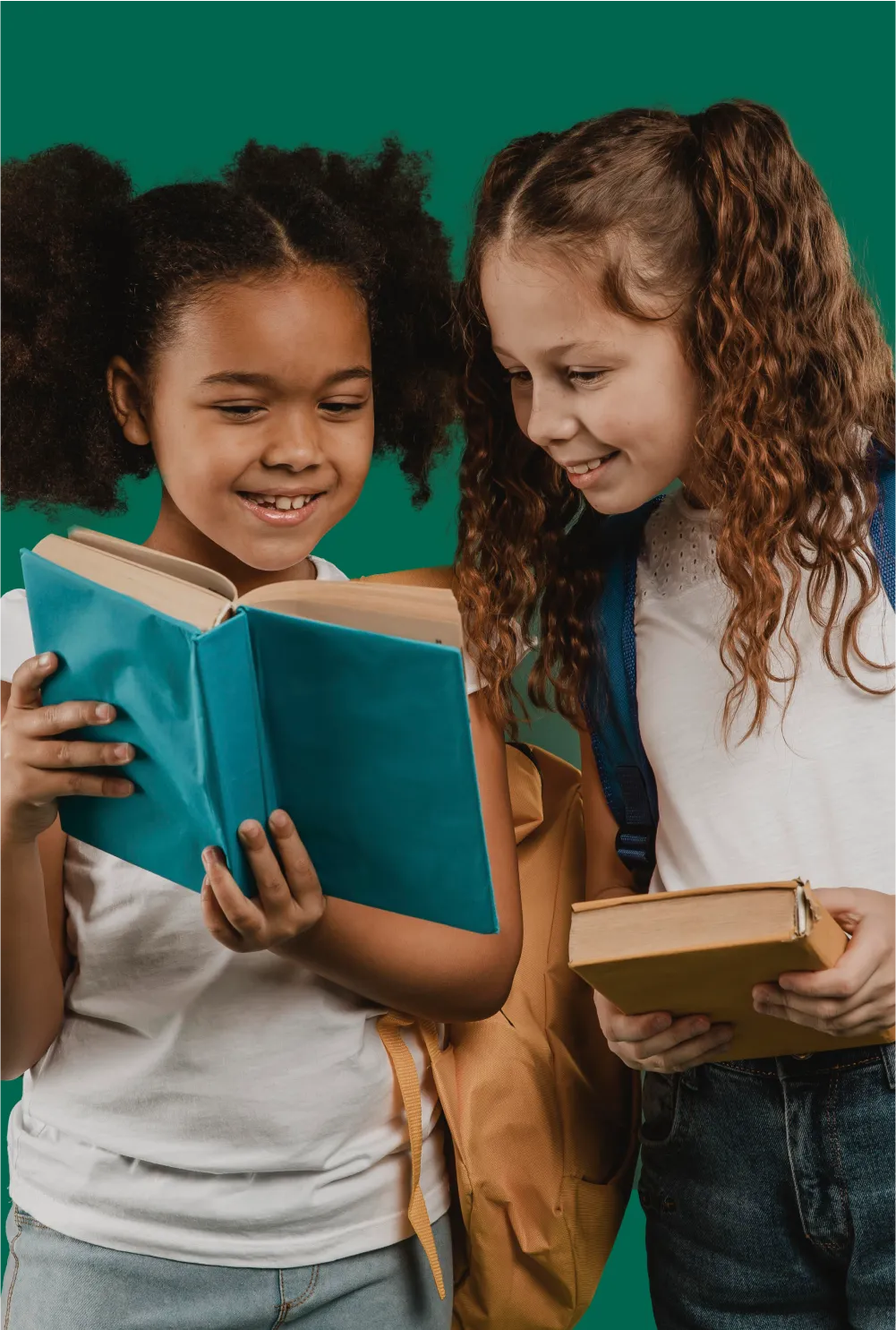 Two young girls are reading a book together.