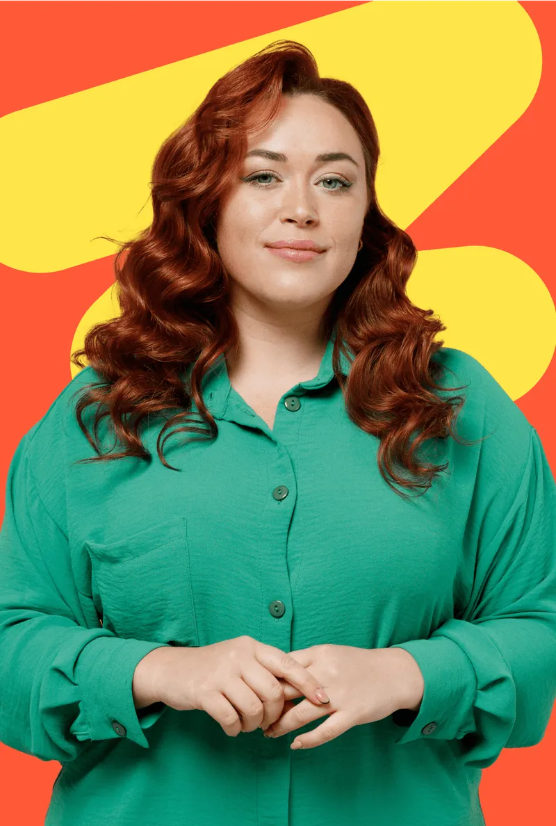 A woman in a green shirt standing with her hands folded.