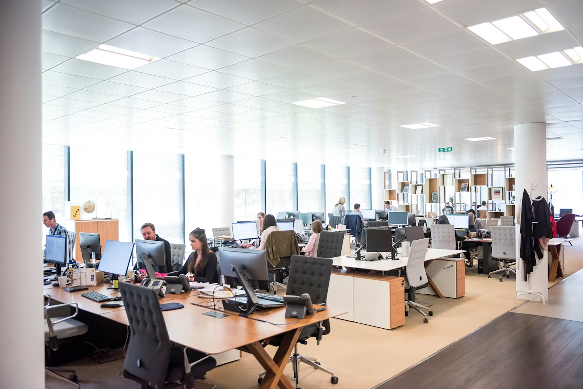 Modern customer service office with agents working across multiple workstations, supporting omnichannel customer experience operations.