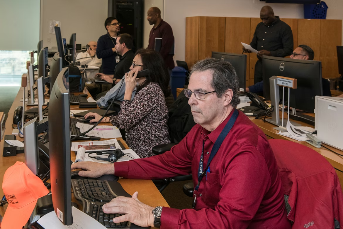Call center employees managing customer calls and support requests in a busy contact center operations environment.