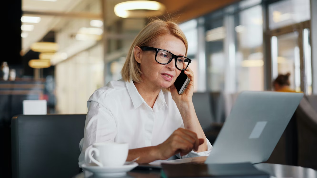 Insurance claims representative using AI fraud detection software while speaking with a customer during a phone claim