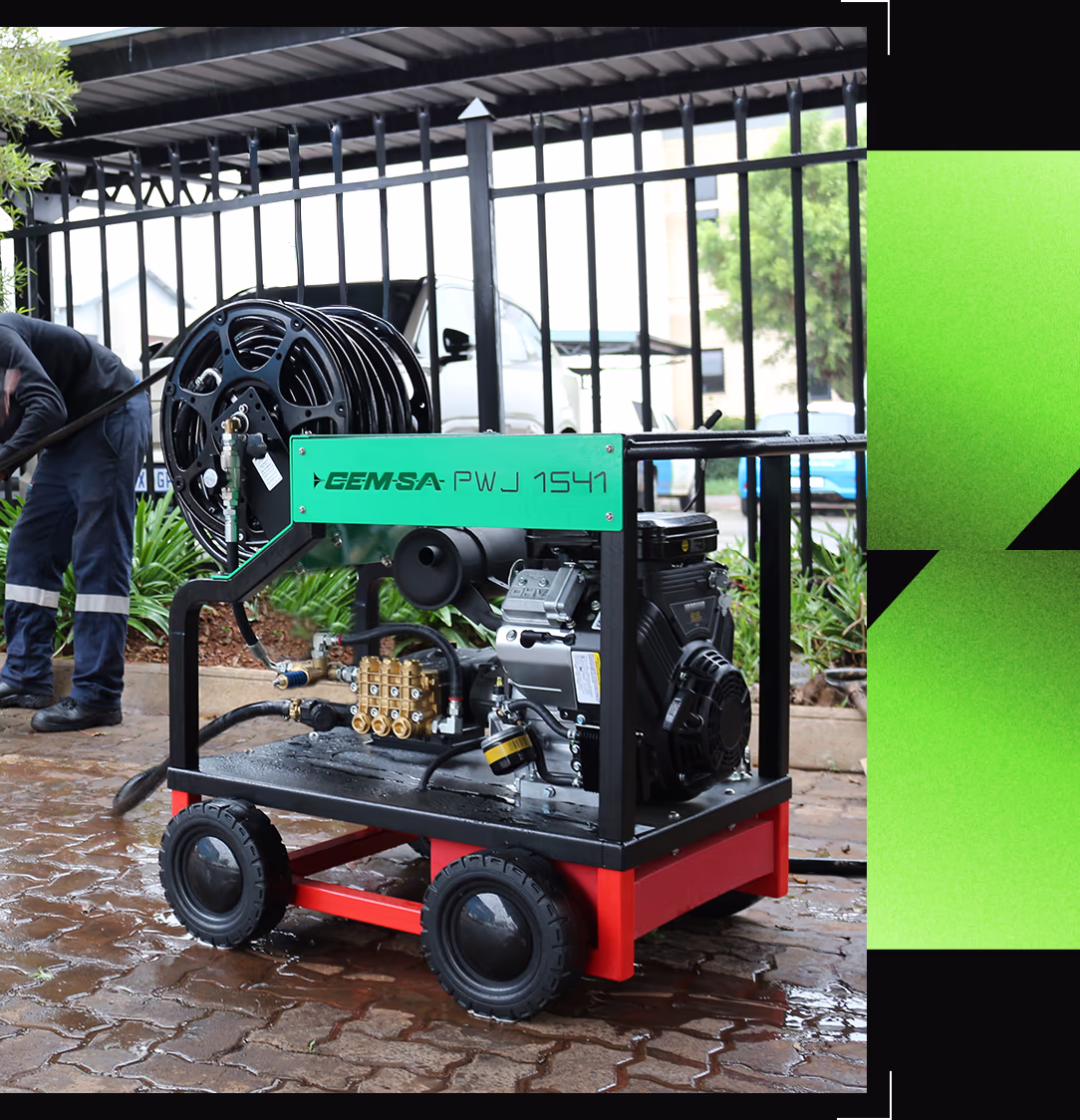 Green, black, and red drain jetting machine outside in the rain