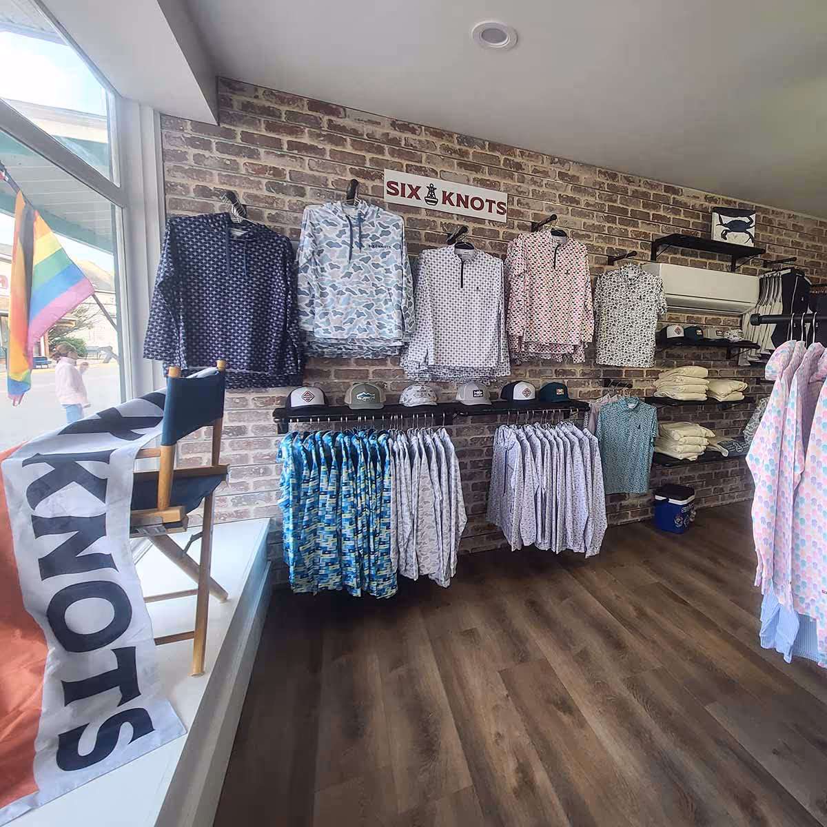 Interior of The Green Hero retail store in Rock Hall, Maryland, featuring a display of Six Knots coastal apparel, including performance gear and lifestyle clothing for boaters and anglers.