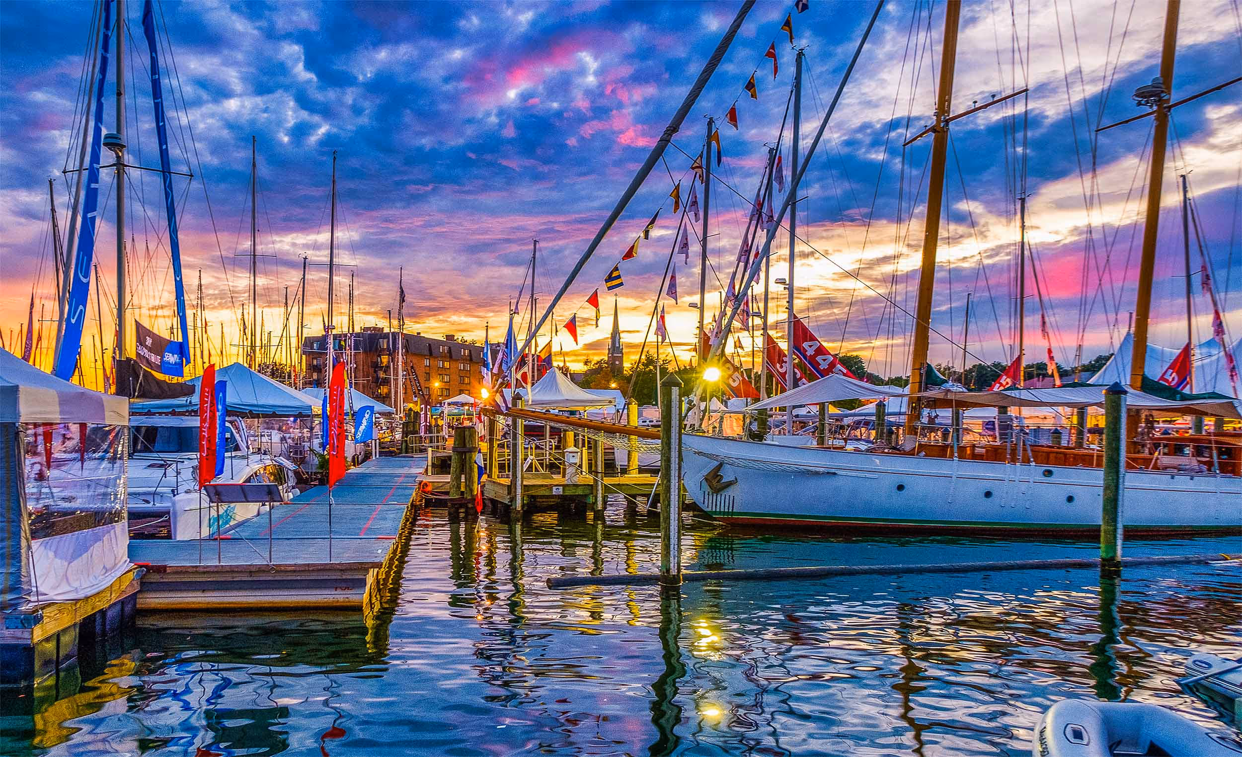Sailboats docked at a Chesapeake Bay marina during a scenic sunset, highlighting coastal lifestyle and waterfront boating culture