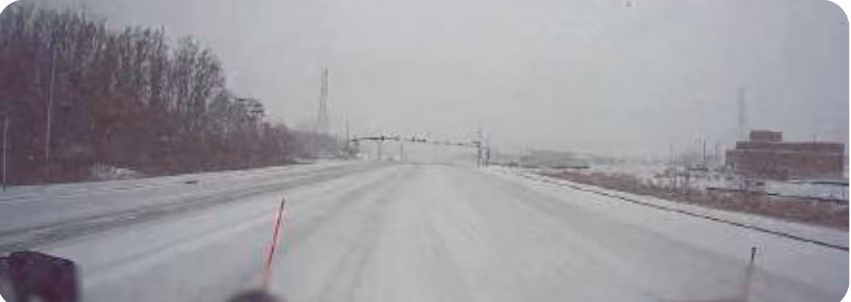 Snowplow dash cam view of a road fully covered in snow