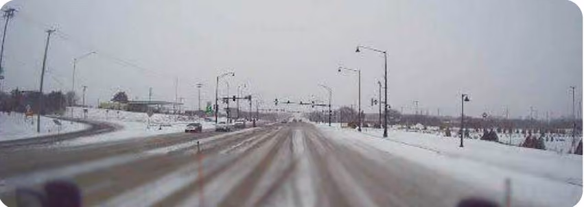 Snowplow dash cam view of a road about half clear of snow