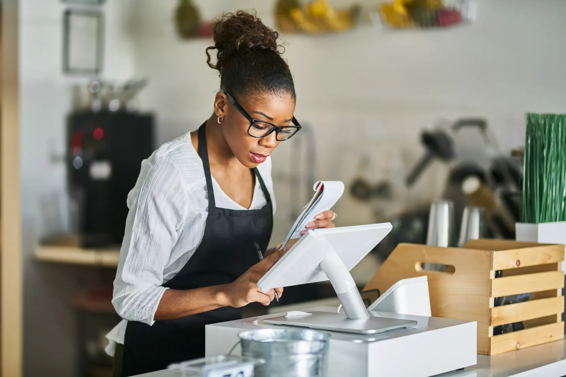 woman in apron using pos for order
