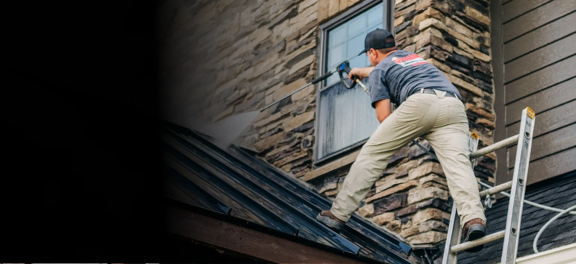 buckeye employee on ladder power washing a residential home