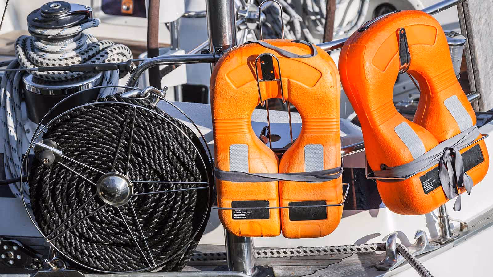Bright life jackets and coiled rope neatly arranged on a boat deck, emphasizing essential boating safety gear and maritime preparedness.