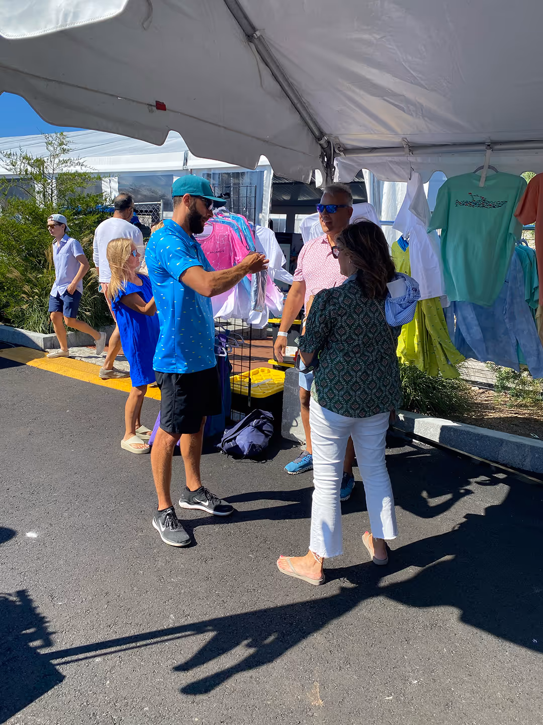 John from Six Knots interacts with customers at the Six Knots booth, bagging merchandise at the Newport International Boat Show
