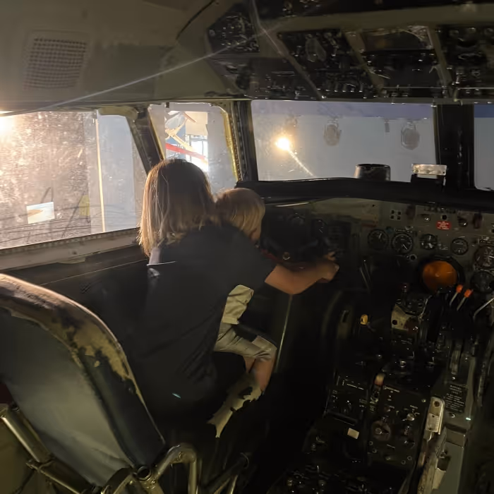 kid playing with controls of a large vehicle. 