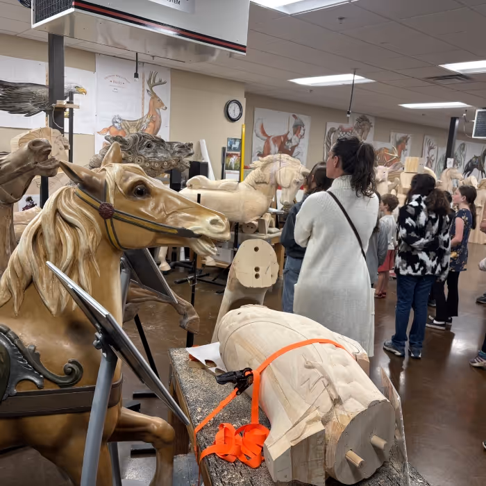 group of people looking at horse mannequins. 