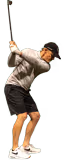 Man in casual clothes swinging a golf club, preparing to hit a golf ball.
