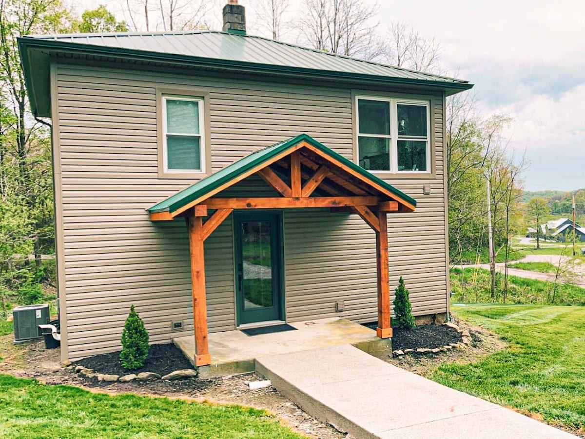 The Oaks, a renovated 1920 farmhouse with a covered entry, in Dundee, Ohio