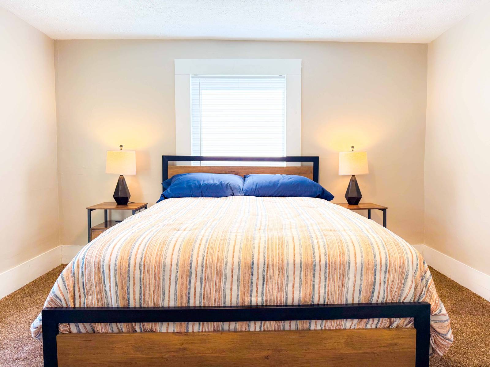 Upstairs bedroom with a striped quilt