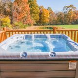 Six-person hot tub on the Deer Creek Cabin deck overlooking autumn woods