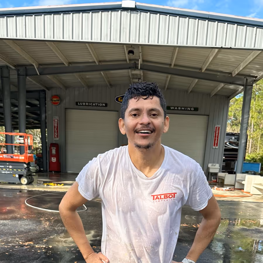talbot painter smiling in front of a commercial paint job