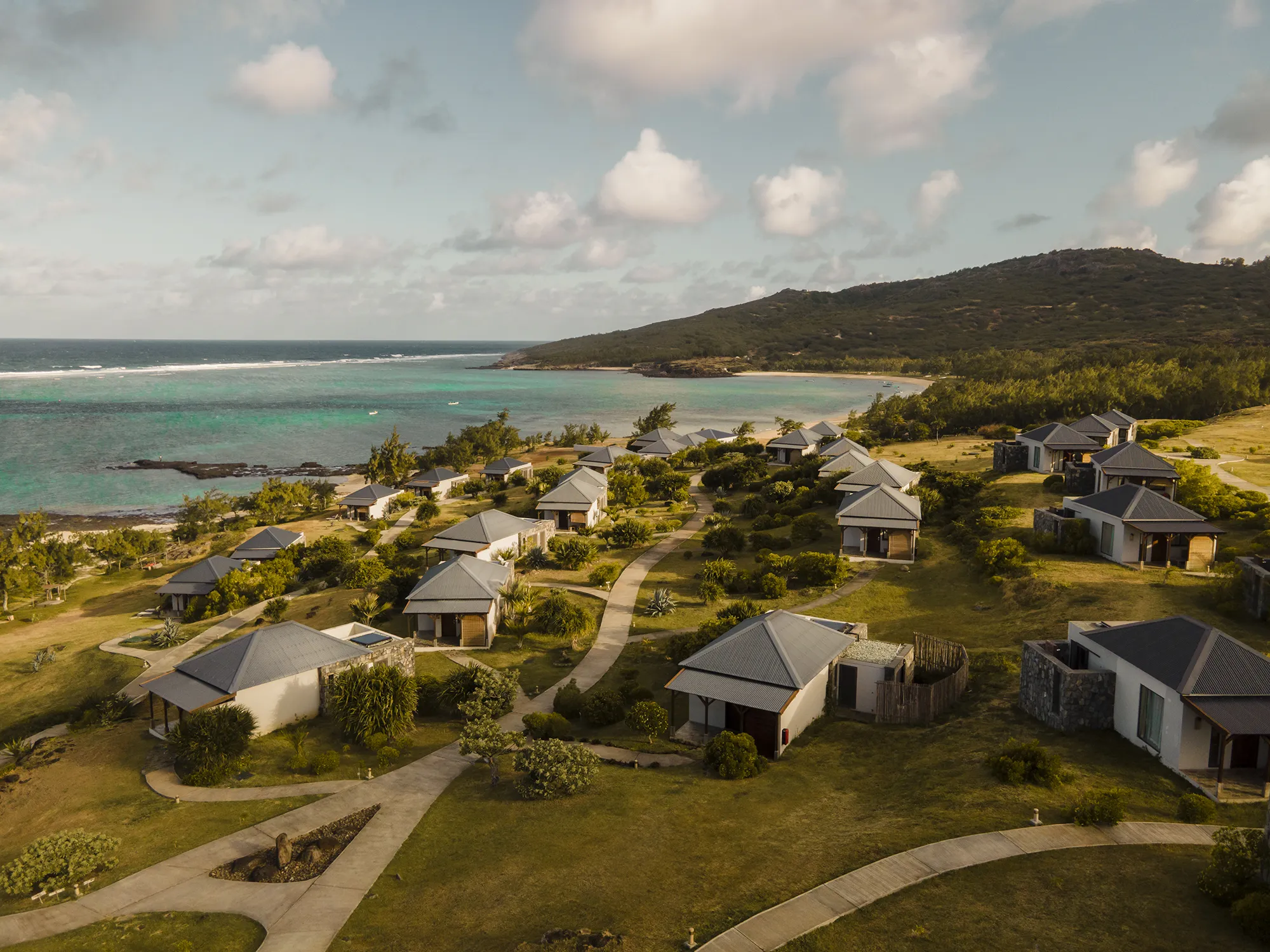 Villor utspridda i ett grönt landskap ner mot havet på Constance Tekoma på Rodrigues