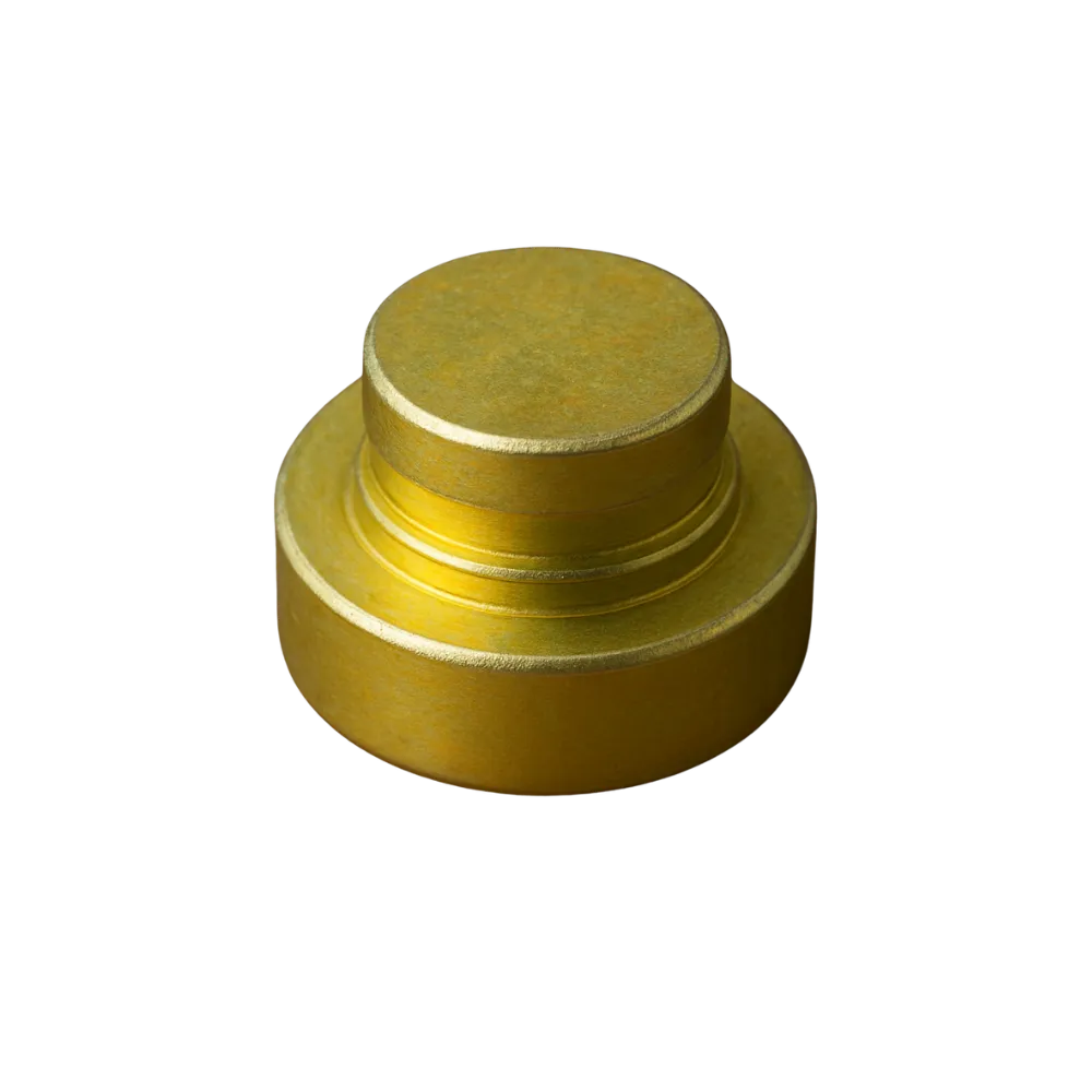 Close-up of a trivalent yellow round metal object with a stepped cylindrical shape.