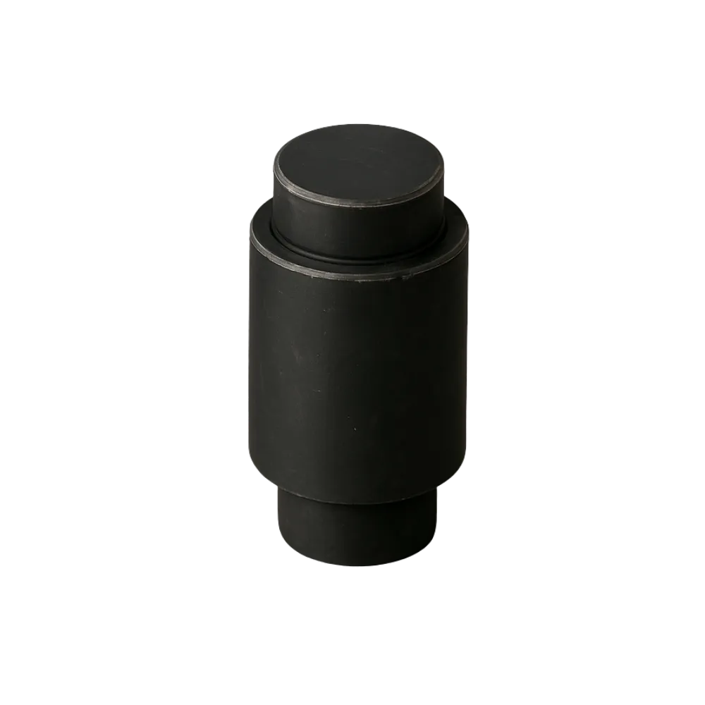 Black cylindrical heavy phosphate rubber vehicle bushing isolated on black background.