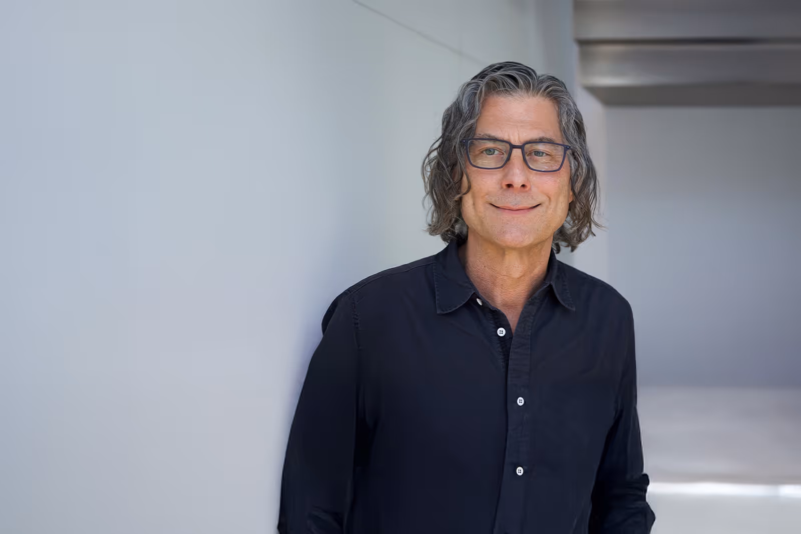 Professional headshot of doctor Robert Poe psyd, standing in a bright lobby and looking calmly at the camera.