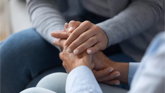2 people holding hands is a supportive way