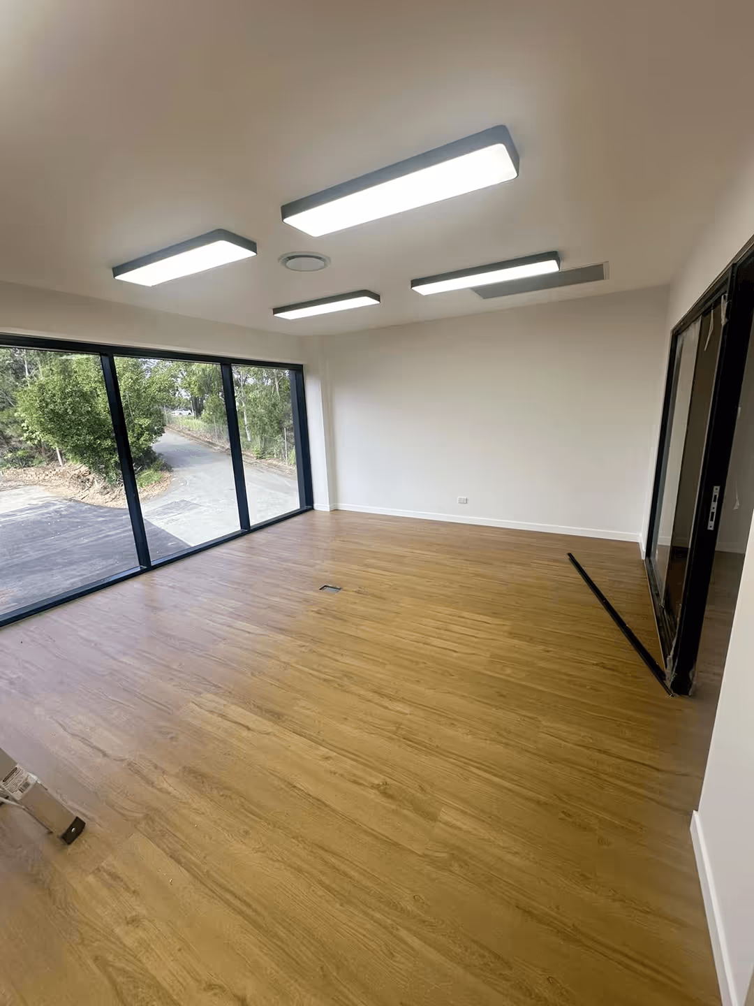 Fully painted new-build commercial office space with fresh walls, newly painted ceilings, clean baseboards, windows, and neatly finished room entrances, all contributing to a professional look.