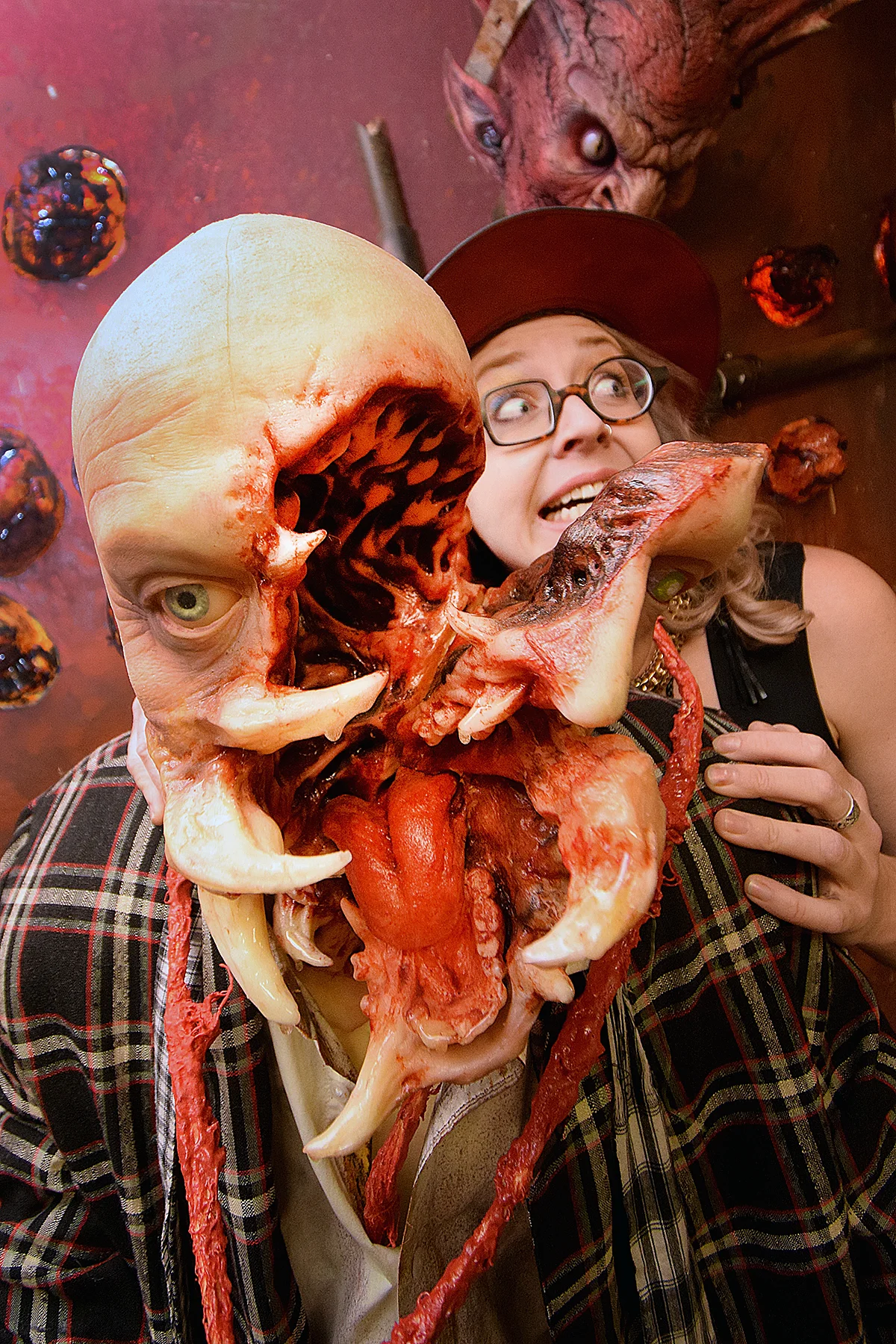 Holly posing with a split-face creature prop in the workshop