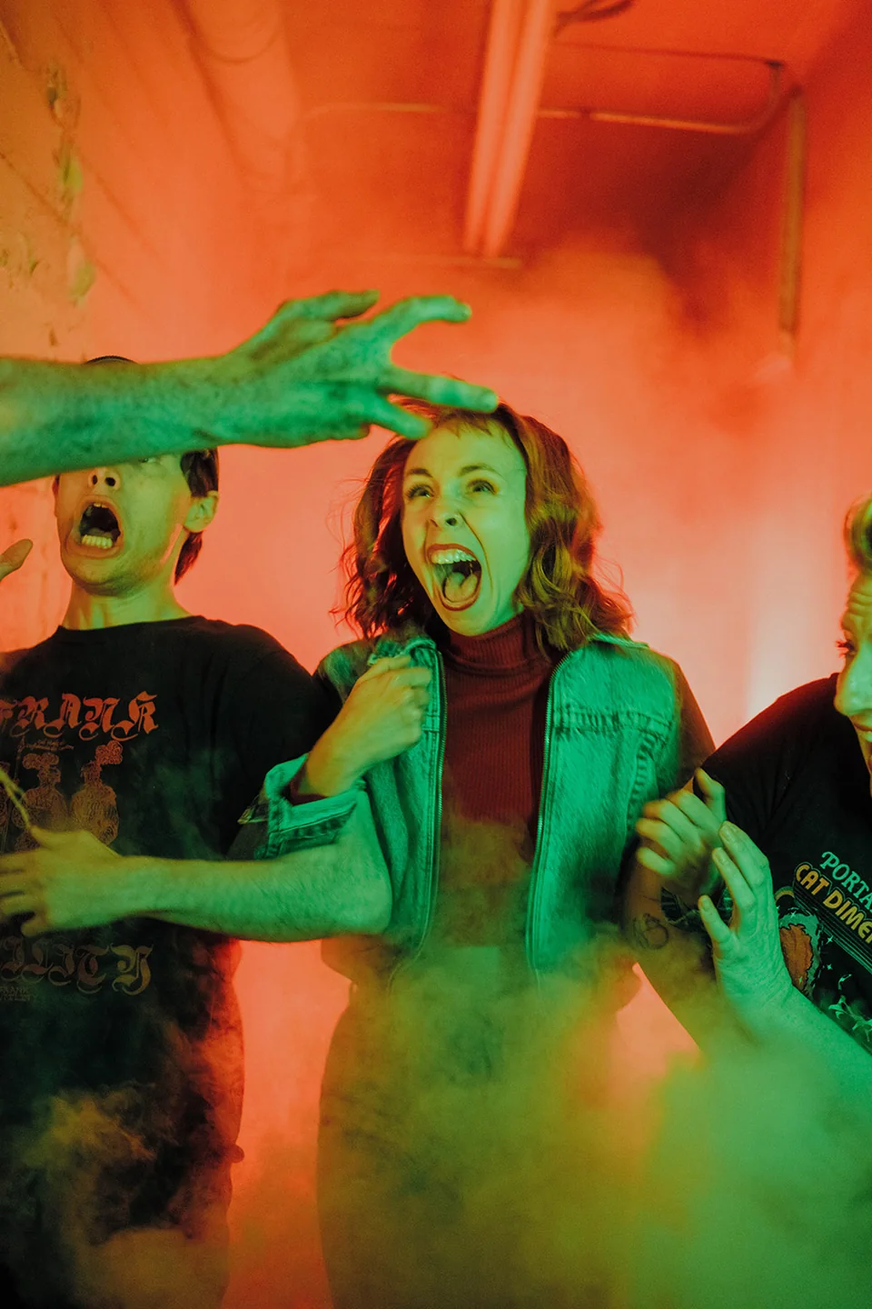 People react in orange theatrical fog.