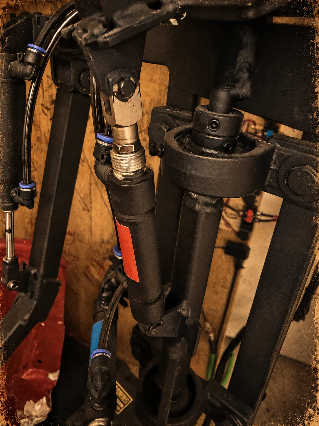 Close-up of pneumatic cylinders, air lines and steel linkages inside an animatronic