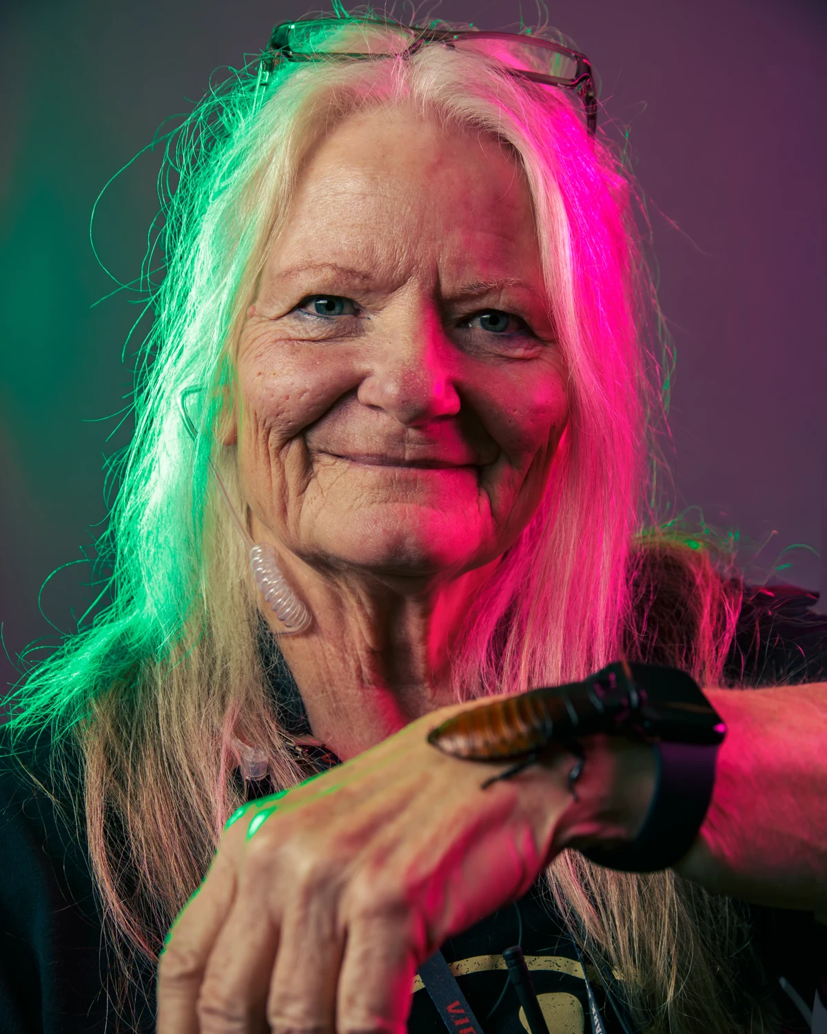 Cockroach handler Gayle Anderson smiling with a cockroach on her wrist