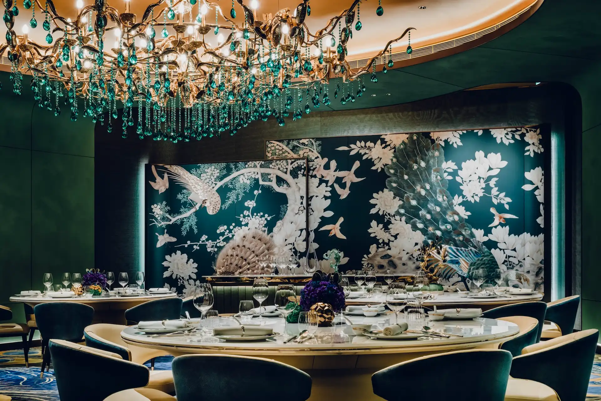 Emerald Room at Grand Imperial Court, MGM Macau, with an emerald crystal chandelier, peacock feather tapestry and round dining table