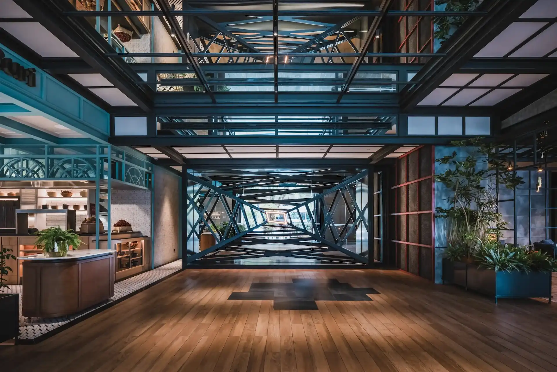 Arrival lobby at Hyatt Centric City Centre Kuala Lumpur, with teal steel framing and a sculptural wall depicting the view up a tin mining dredger crane shaft