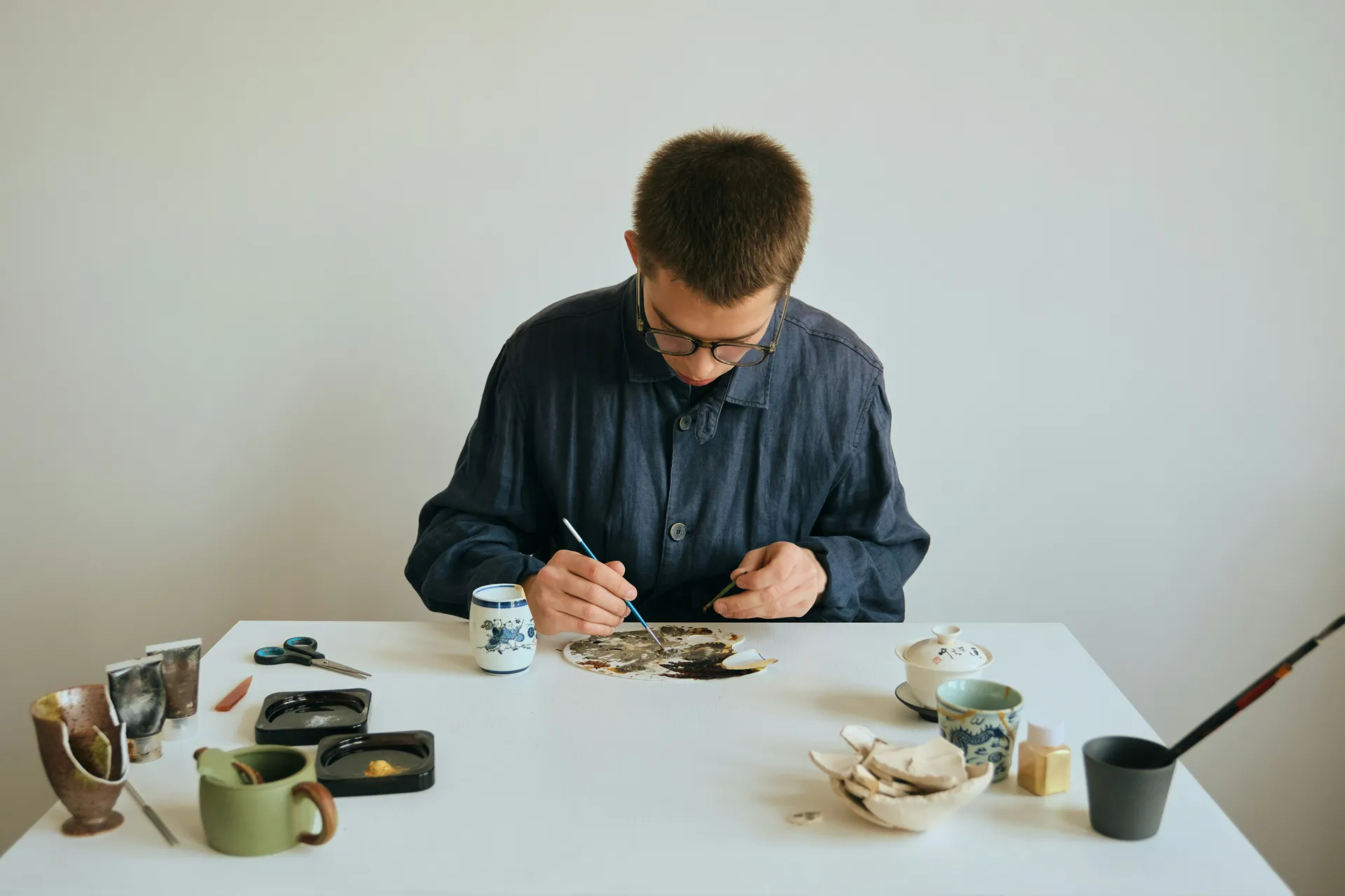 Craftsman repairing broken pottery using the Japanese kintsugi technique