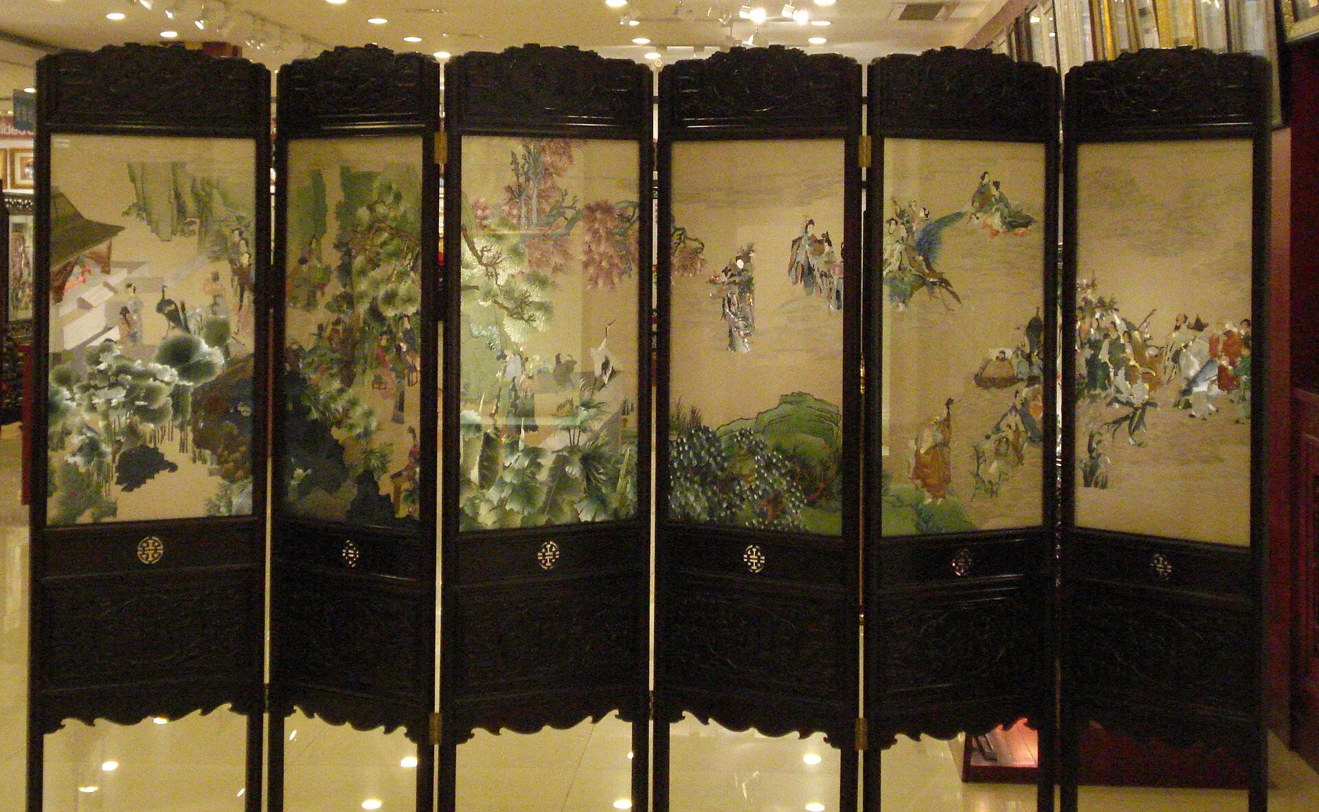 Embroiderers working on silk stretched on frames in a Suzhou workshop