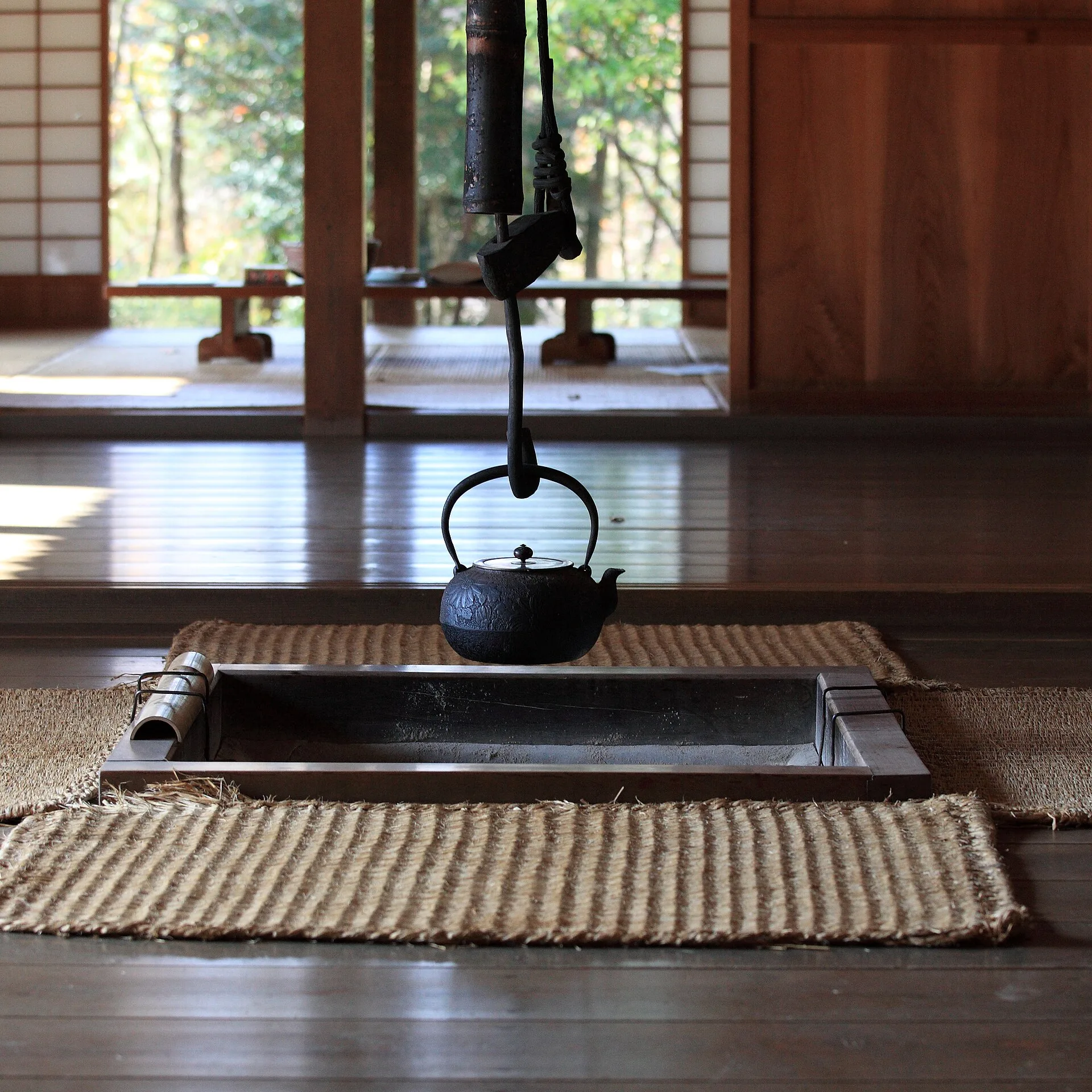 Iron kettle hanging over an irori hearth