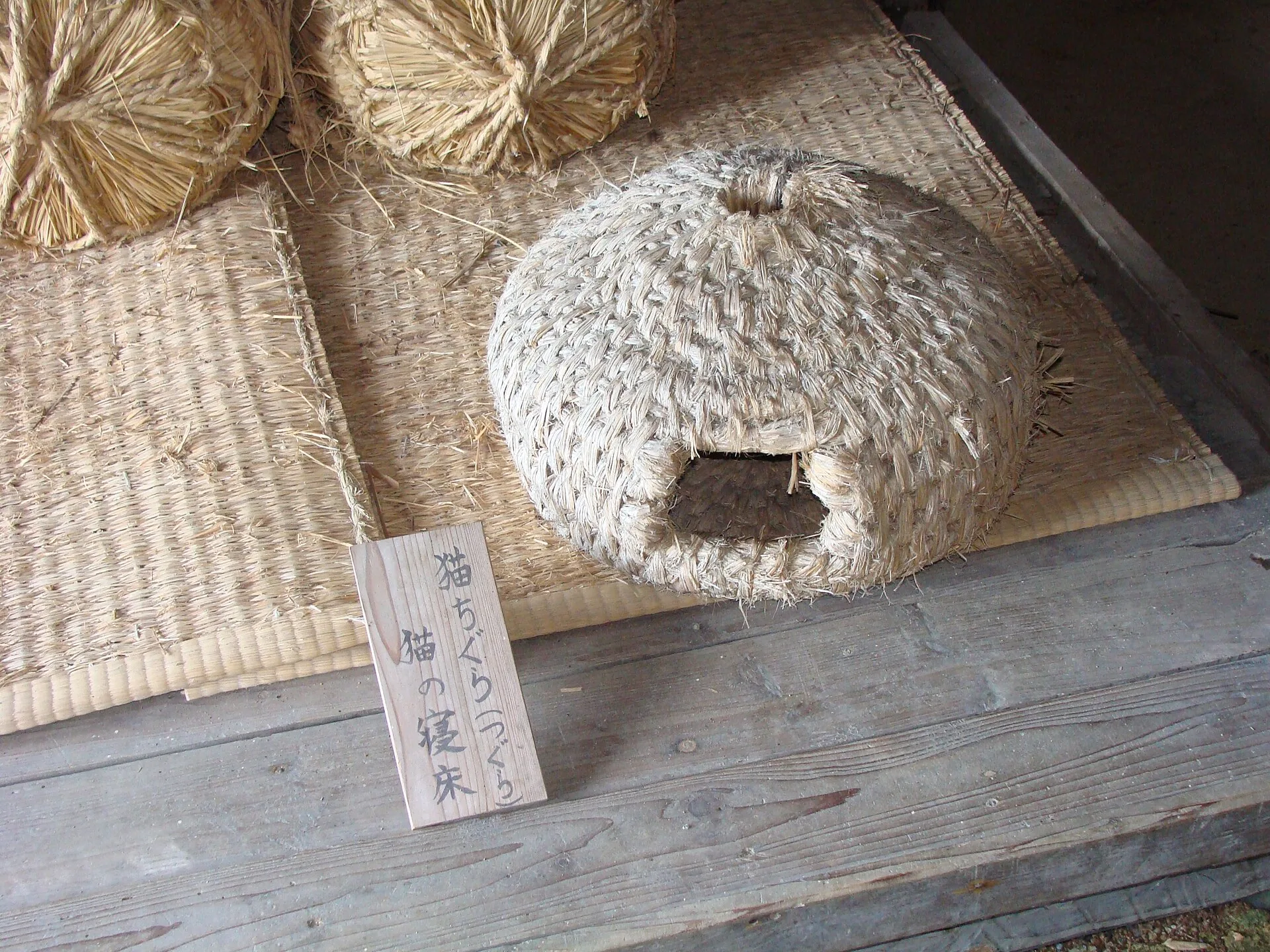 Domed woven straw cat house with a round entrance
