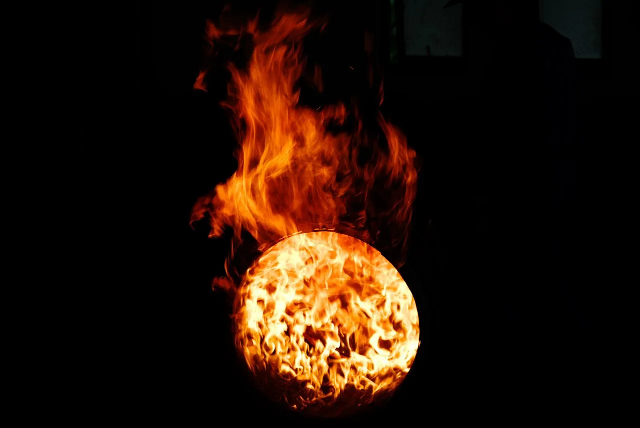Flames burning inside an open oak barrel during charring