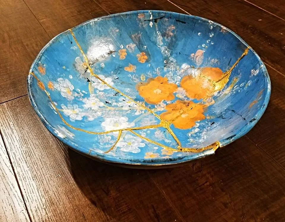 Blue hand-painted pottery bowl with cracks repaired in gold