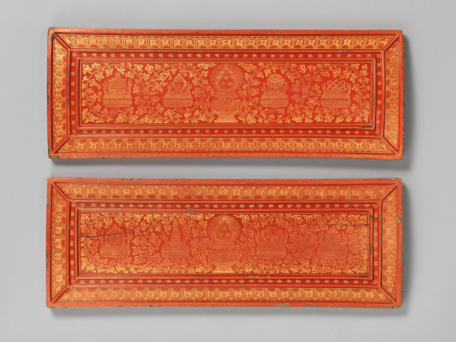 Pair of red lacquer sutra covers incised in gold with Buddhist emblems
