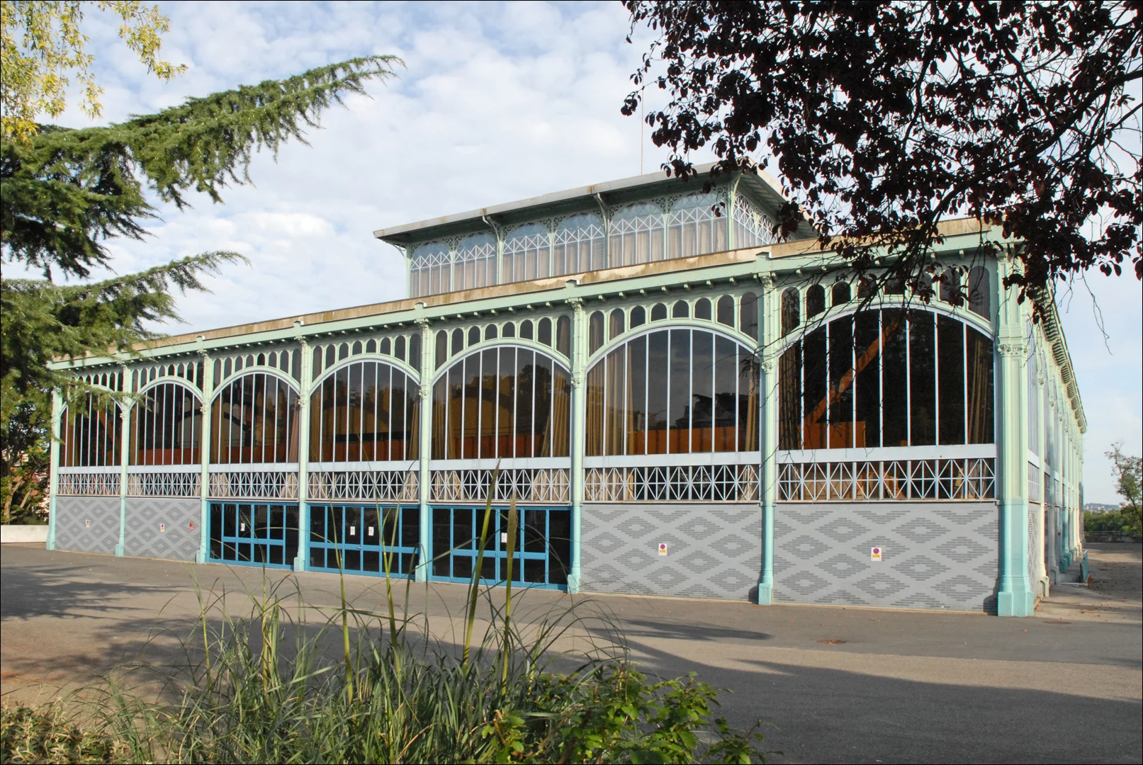 Iron and glass Baltard market pavilion with tall windows among trees