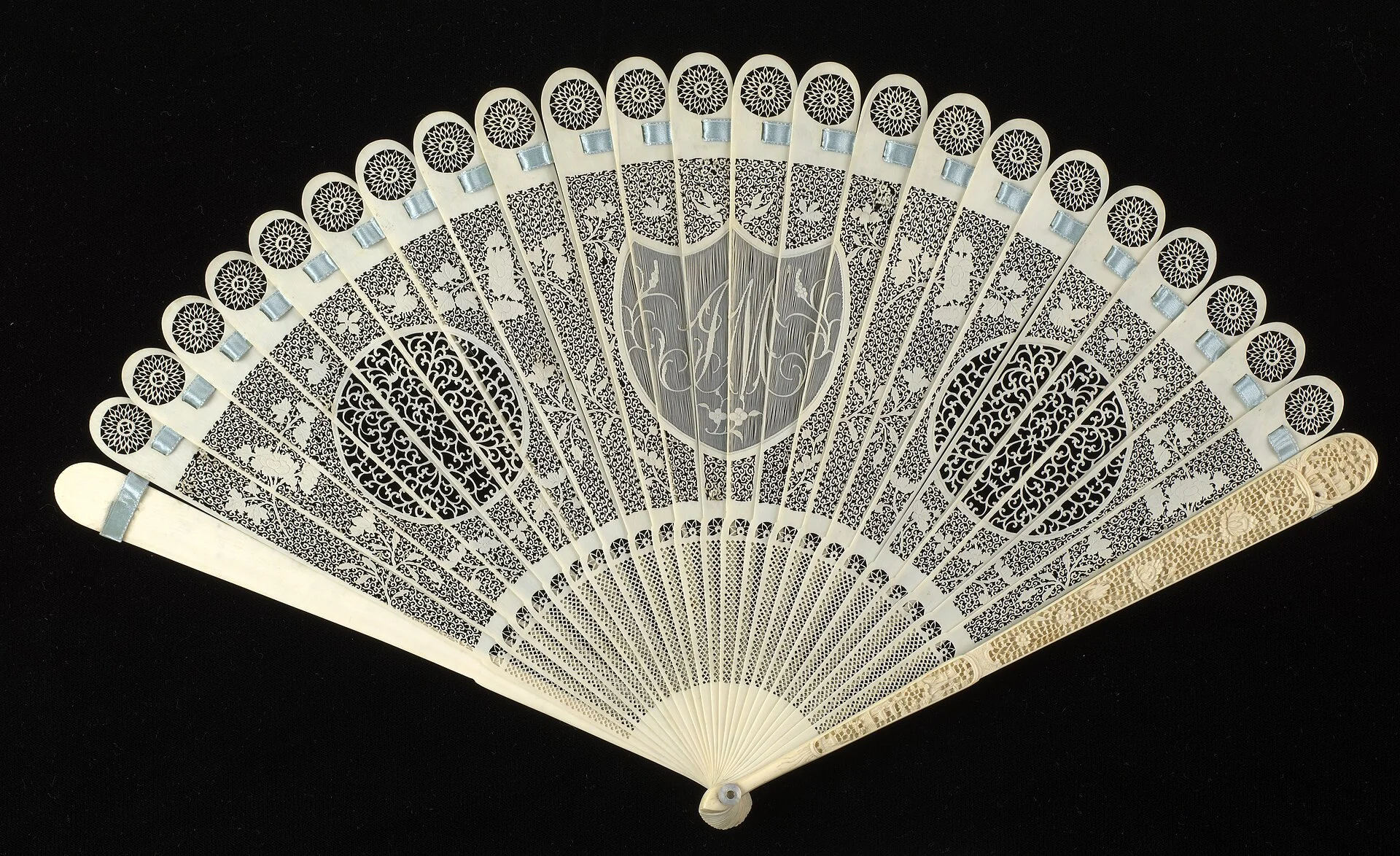 Open pierced brisé fan with carved medallions on a black ground