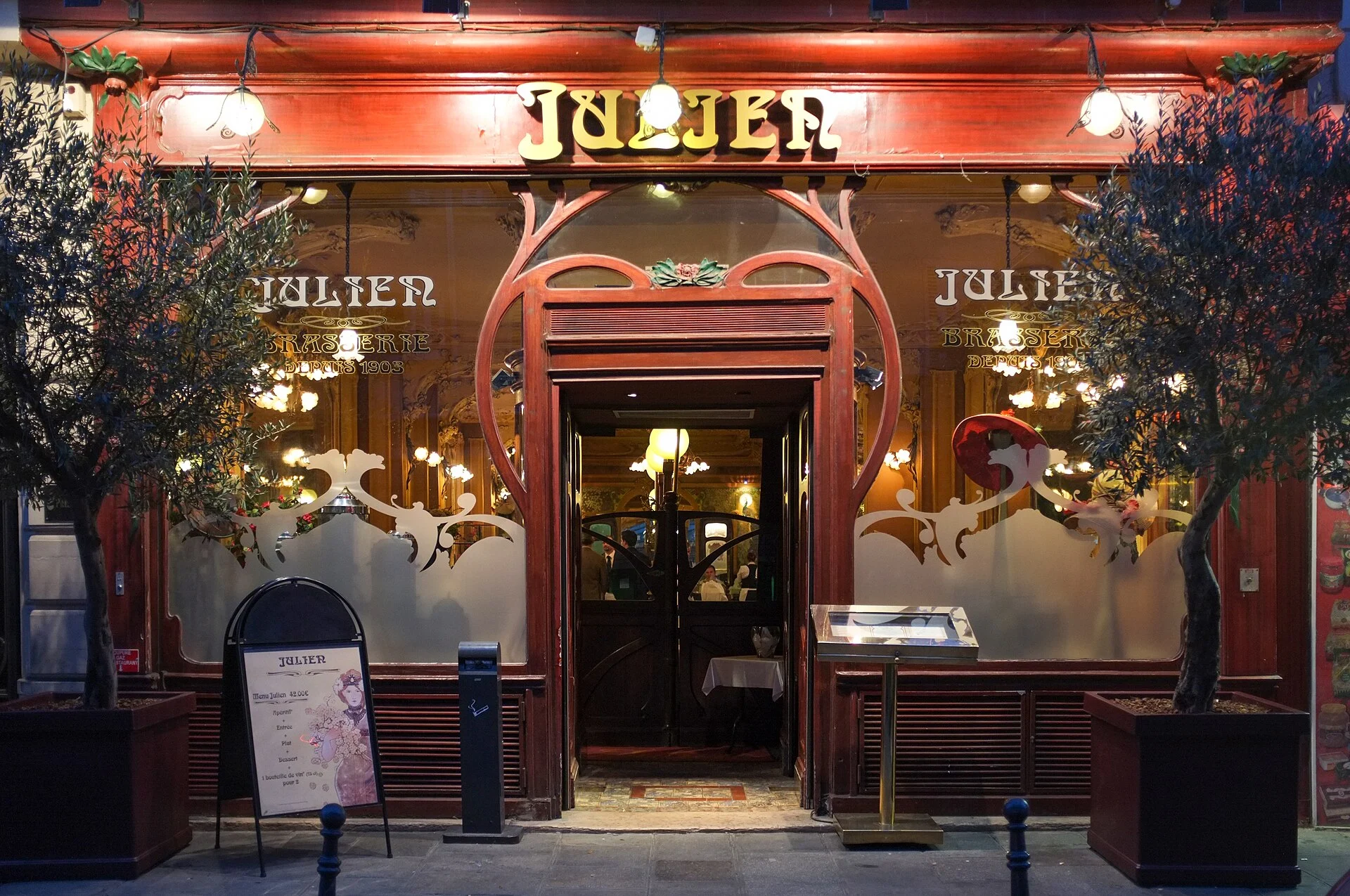 Lit Art Nouveau shopfront of Restaurant Julien at night