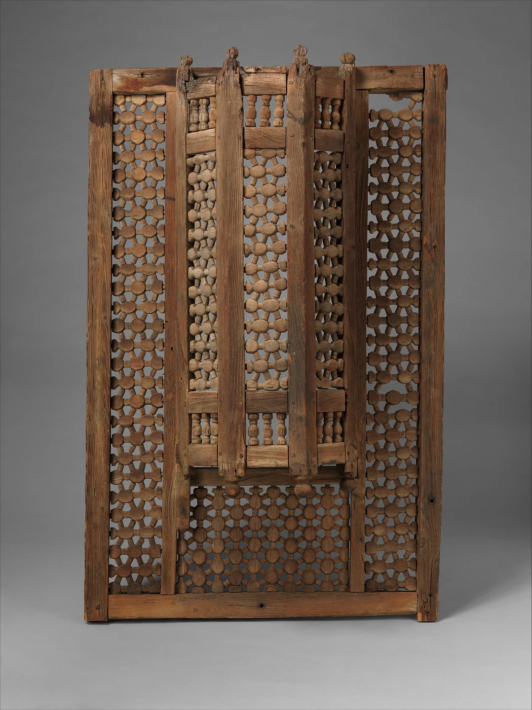 Tall wooden mashrabiya screen with dense lattice panels