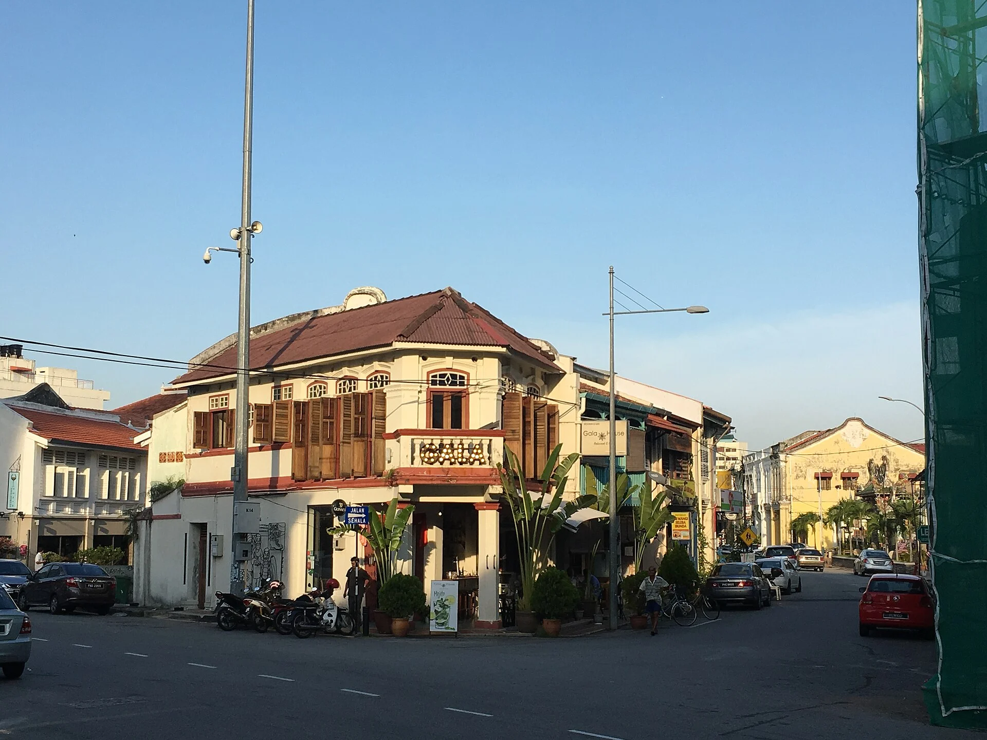 Corner shophouse at a street junction in George Town under a clear sky