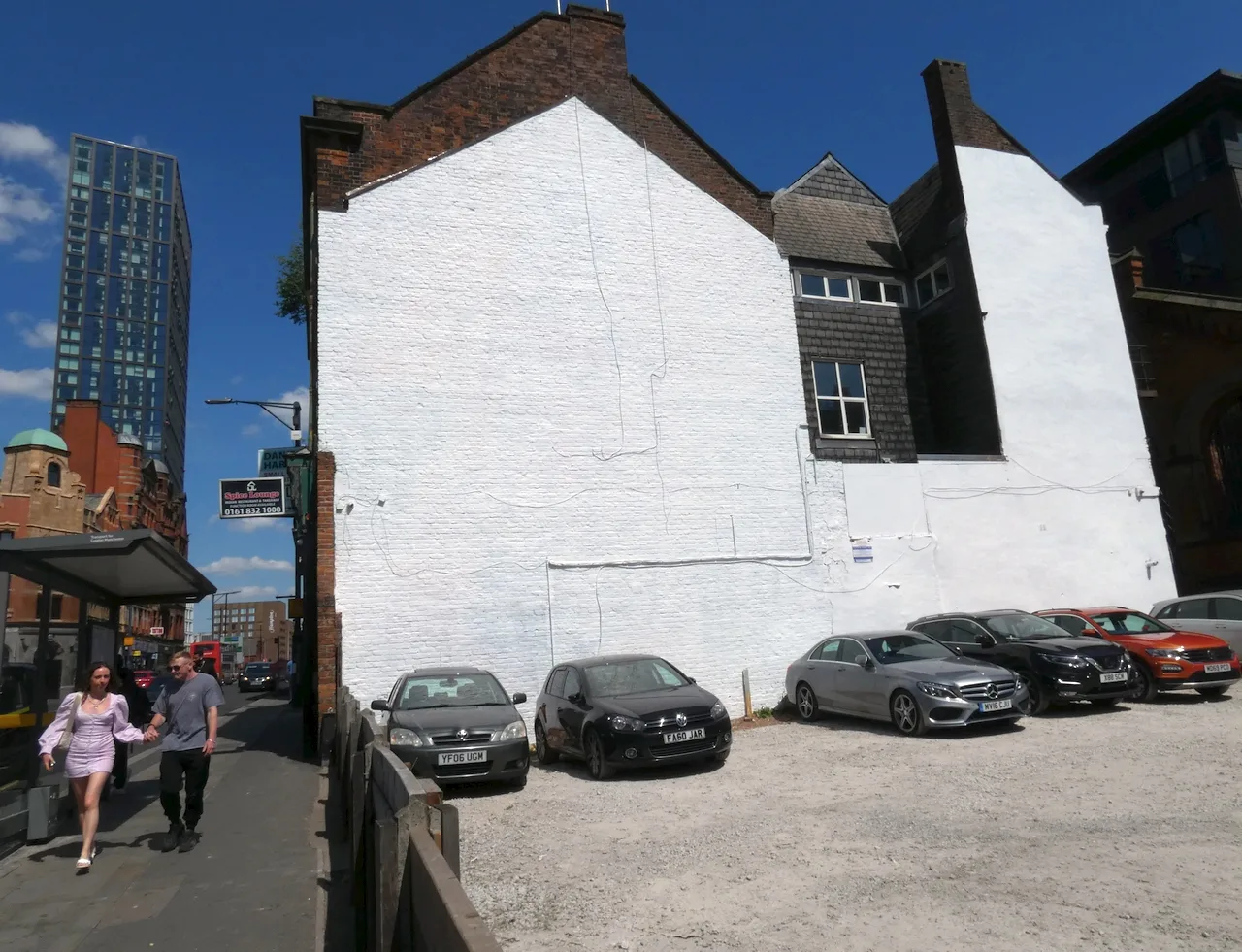 Whitewashed gable wall of a building beside an unpainted brick chimney